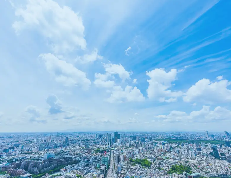 高層ビルが並ぶ街並みと青空が広がっています