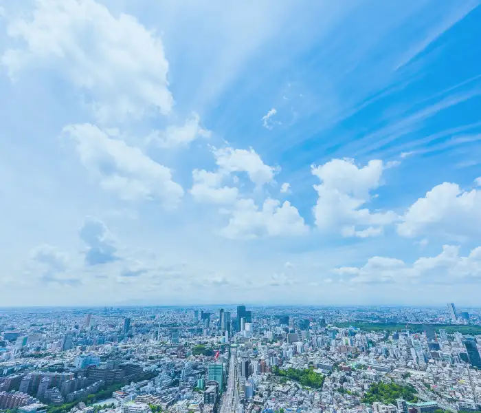 高層ビルが並ぶ街並みと青空が広がっています